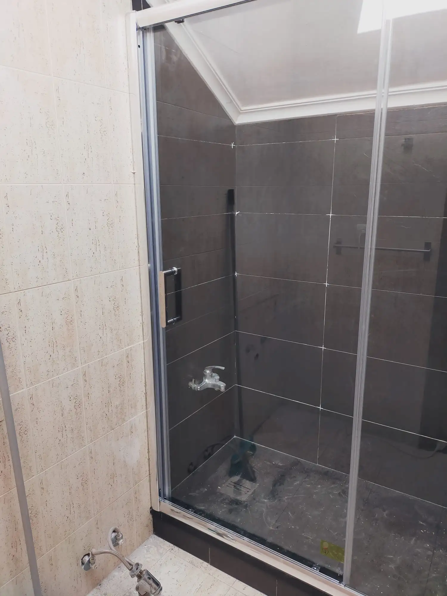 Reforma baño con plato de ducha de obra en gres gris y mampara corredera en Etxebarri
