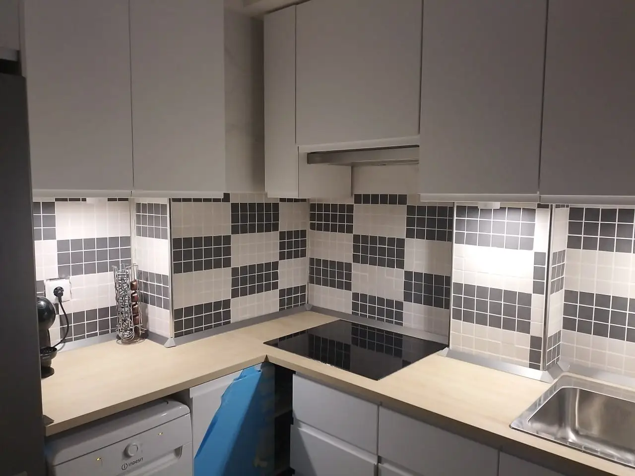 Reforma de cocina con azulejos de mosaico blanco y gris sobre encimera de madera en Etxebarri