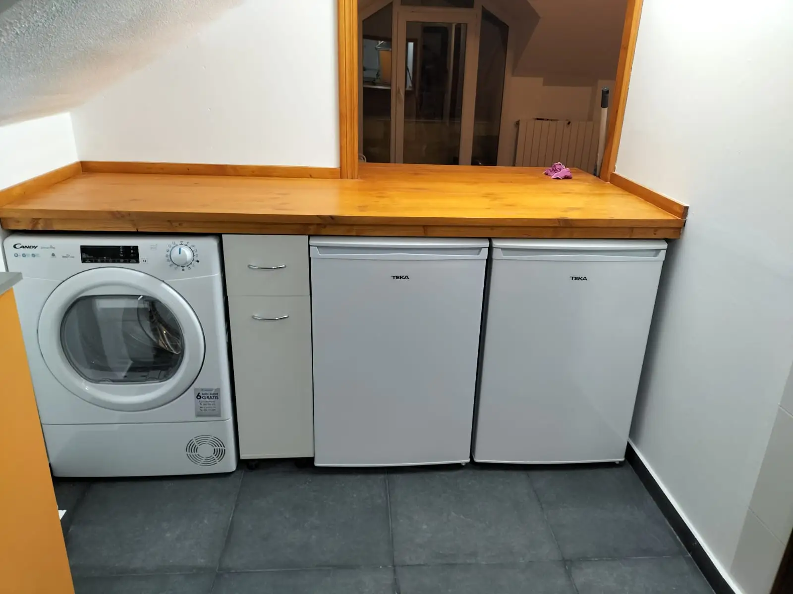 Reforma de cocina con encimera de madera natural y electrodomésticos integrados bajo el mueble en Etxebarri