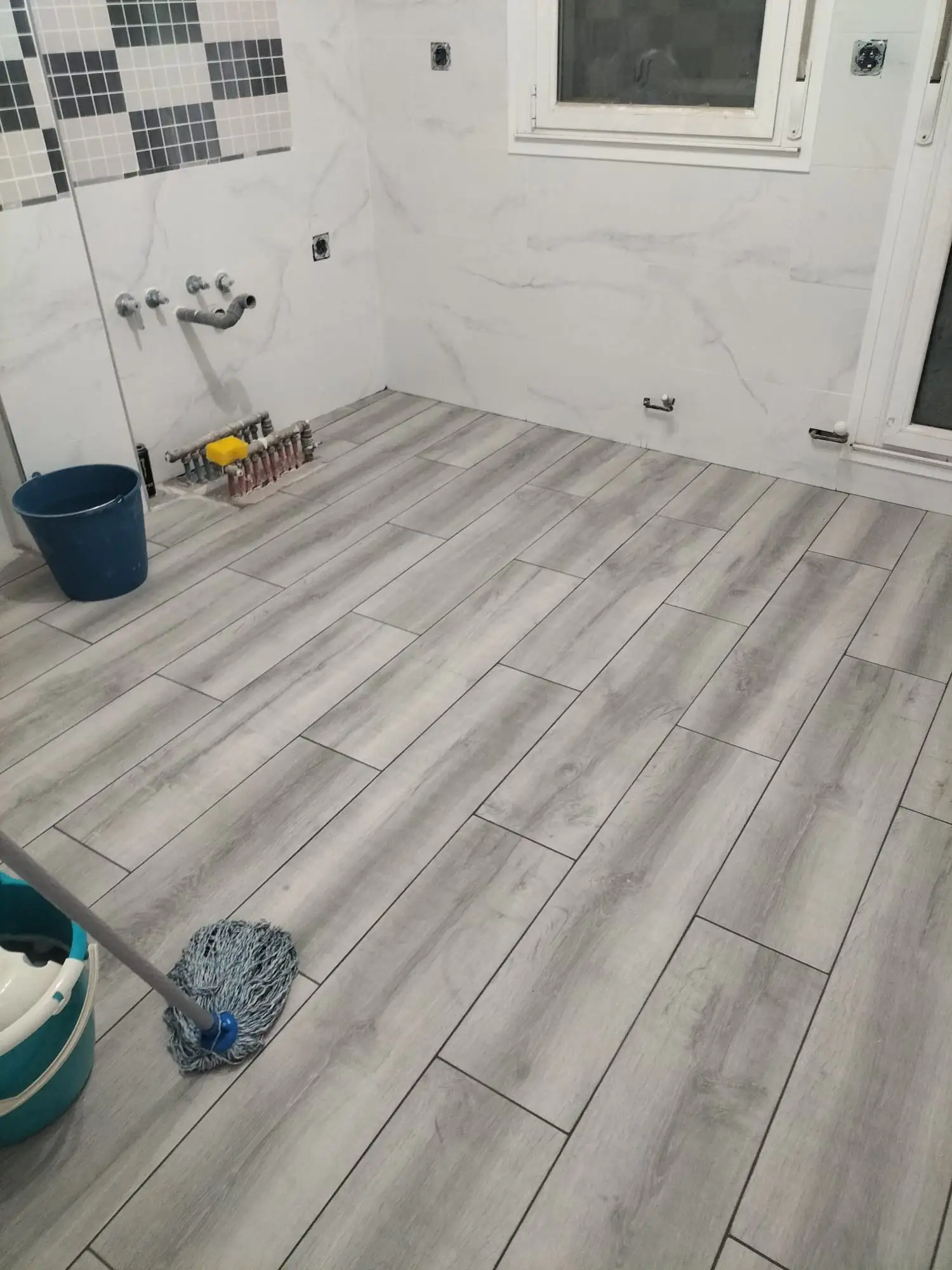 Reforma de cocina con suelo porcelánico imitación madera gris y paredes alicatadas en Etxebarri